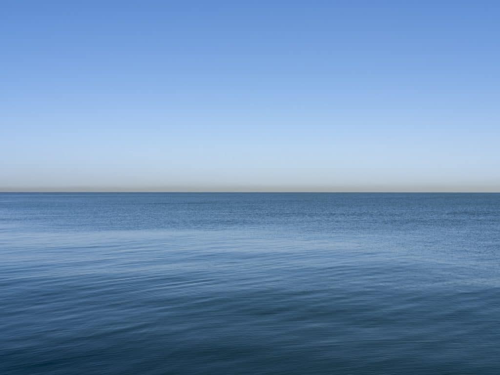Piercingly Blue Lake Michigan rolls gently in the wind under a clear blue sky
