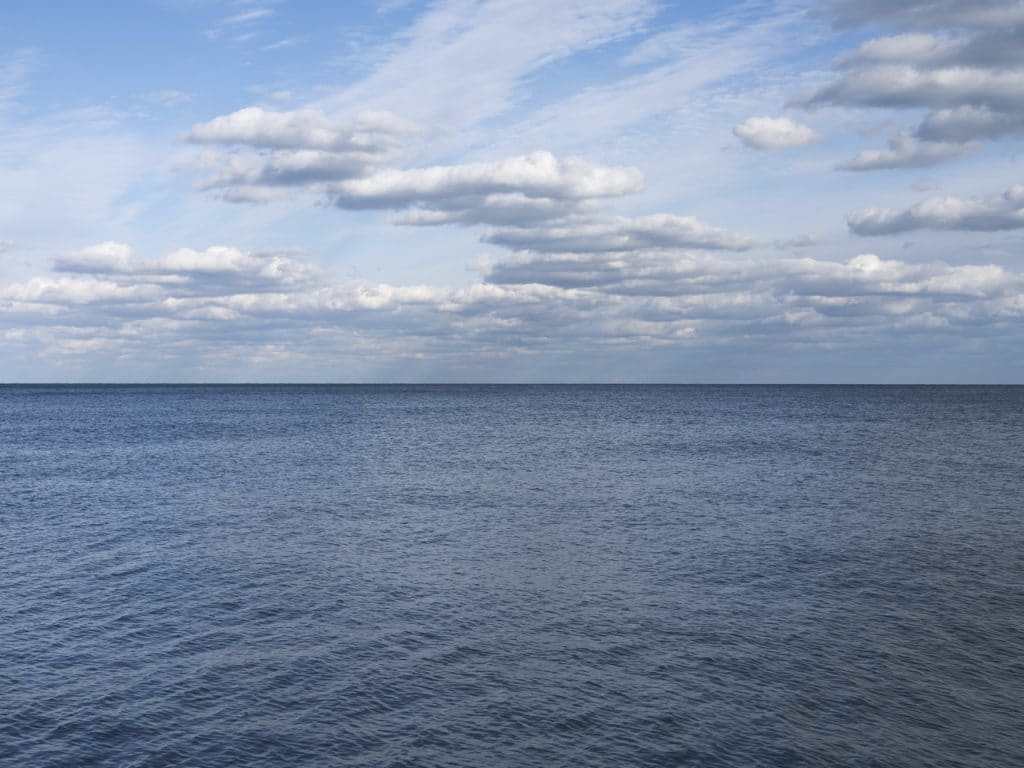 Chicago Blue Skies are lightly filled with soft clouds as the lake sits rippling gently beneath