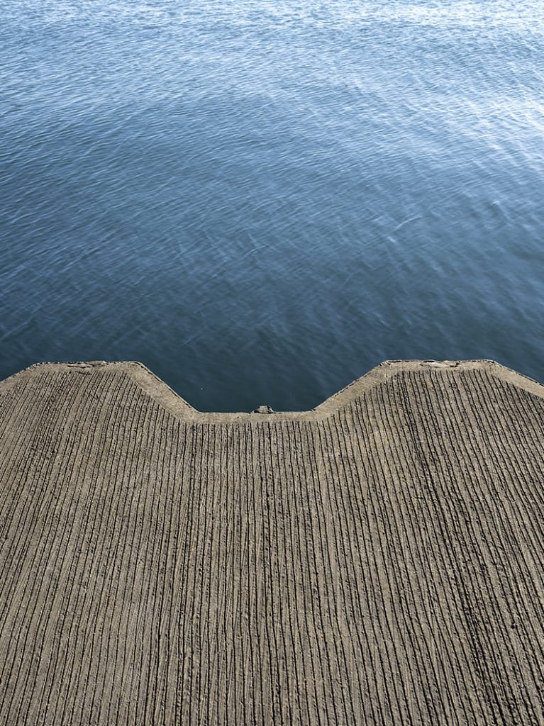 Lake Wall on Lake Michigan is serrated and made of concrete and steel, blue lake waters extend out from it