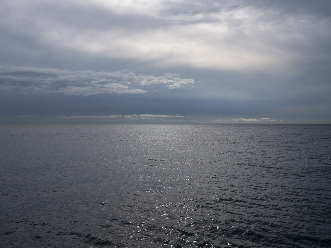 The sky and water meet over the lake in a suspended state, in a holding pattern as winds are dying down on this day from the Lake Series. Storms threaten from the west, but for now the lake waits in anticipation on September 6th, 2023.
