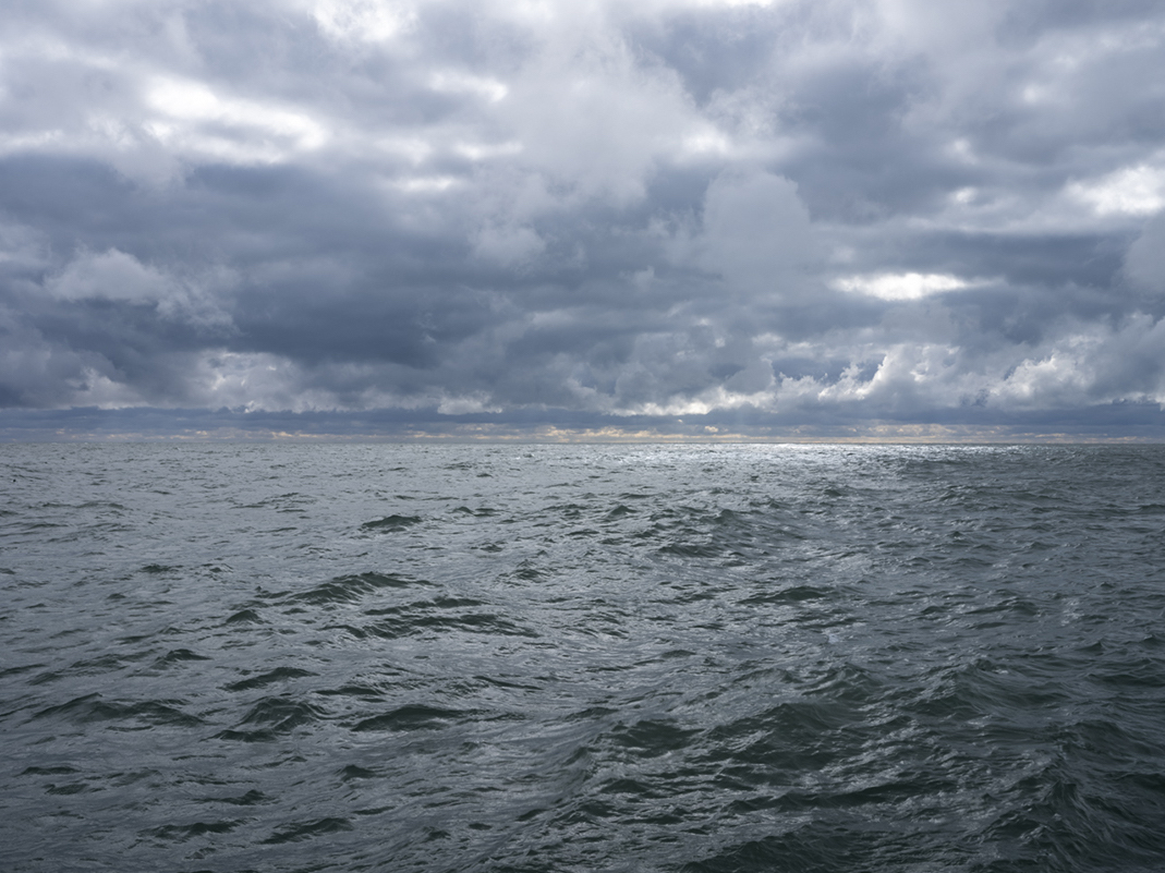 Storms rolled over Lake Michigan finally at the end of August, breaking a streak of hot and dry days with tumultuous storms and weather. The lake is alive, kicking up waves as clouds start to slip apart in the sky. Allowing silvery sunlight through to reflect on the water far from shore.