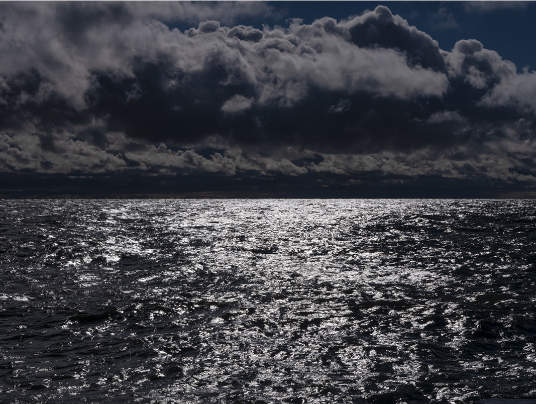Lake Michigan turns its character on a moments notice, a dramatic shift can happen at a moments notice. Shifting rapidly and often catching people off guard. Storms will soon hit the lake waters and the sky will be filled with rain. But for now the water takes on the qualities of an etching. Black and white rendered bold at dawn.