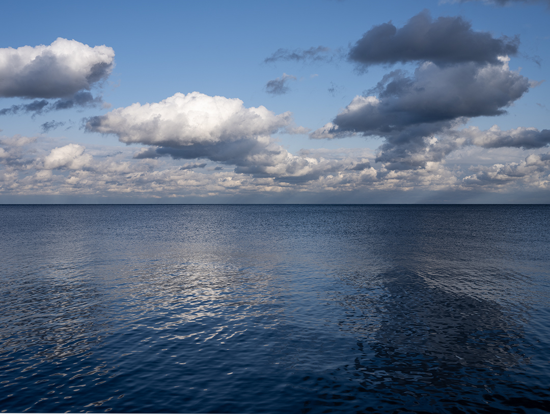 Late fall comes to Lake Michigan and the waters appear as marbled patterns in this photograph from the Lake Series. As the lake moves gently, rippling softly, the sky overhead, blue, white and gray in color, transform into undulating sinuous patterns on the water.