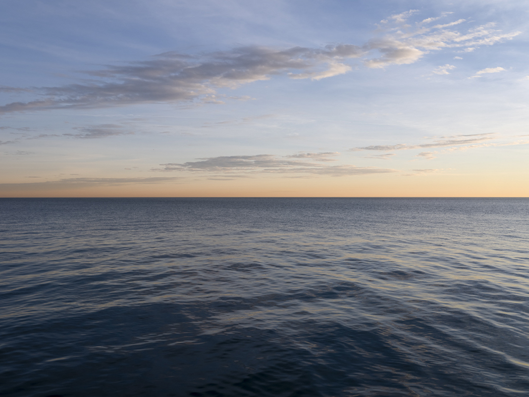 The lake is gently warming in the morning light on December 15th, 2023 in a photograph from the Lake Series, featuring Lake Michigan in an ongoing project that began in September of 2015. Each day, month and year has shown me something new in this landscape. The time spent with the lake has allowed for me to know my subject in ways I could not have imagined when I began this series. It is the endlessly changing nature of the lake that compels me to continue to photograph it and I look forward to seeing what the lake reveals next.