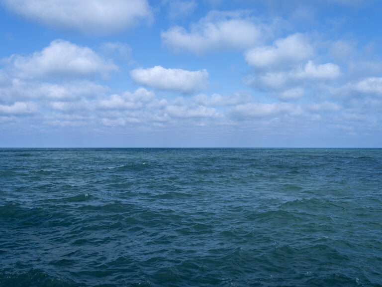 A beautiful blue day on Lake Michigan with soft clouds floating in the sky overhead in this photo from the Lake Series by Lincoln Schatz.