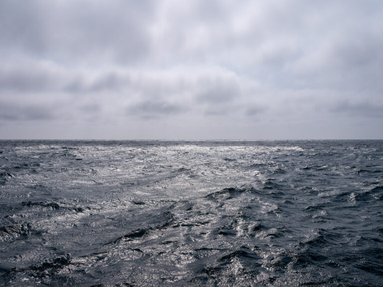 A silver day on Lake Michigan where the clouds are filtering the light in eerie ways.