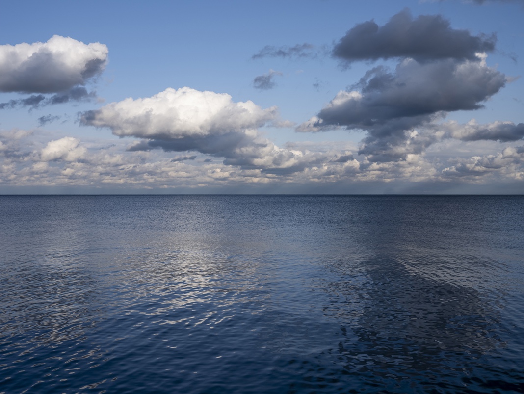 From an early October day last year, a perfect fall landscape on Lake Michigan with loose and open clouds cause the lake waters to reflect and mirror the air overhead. Creating marbled patterns in blues and whites on the lake.