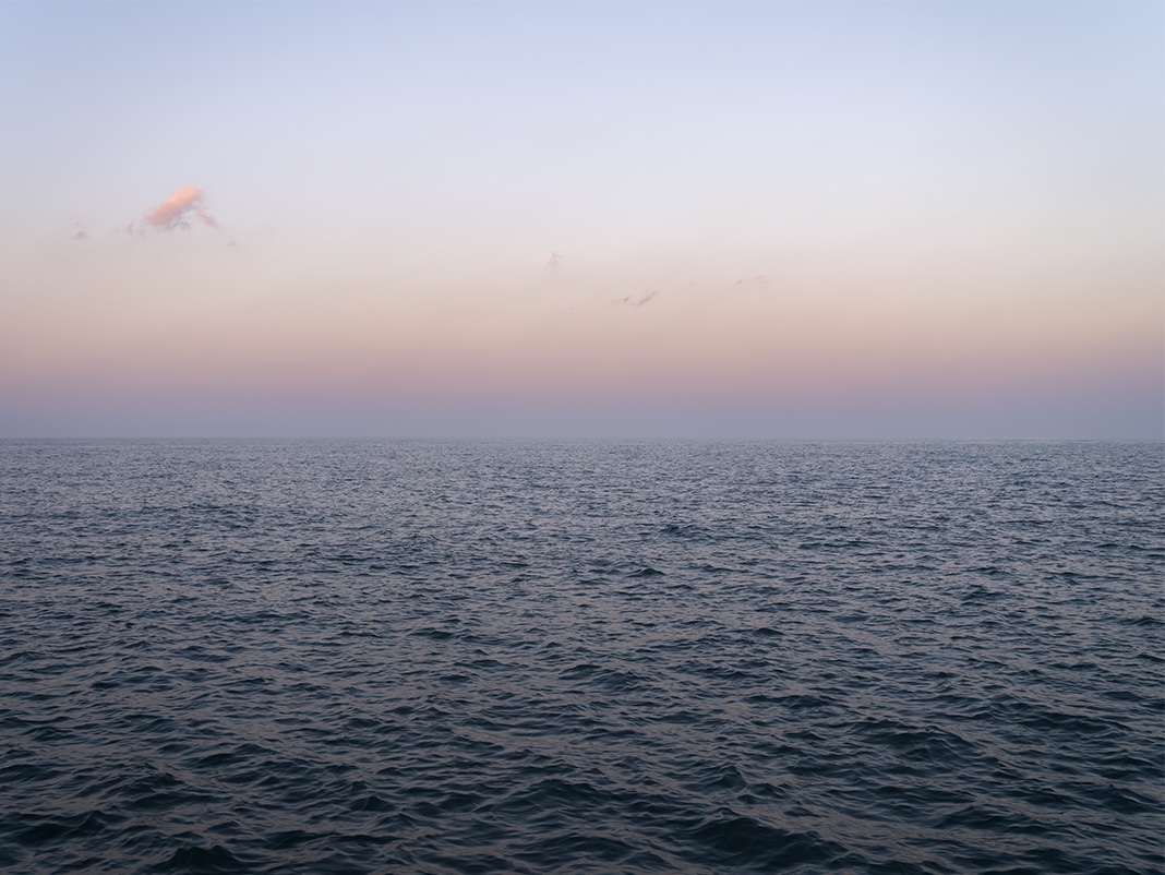The sky shifts in an ombre from cool to warm to cool again as the sun sets at my back while I photograph Lake Michigan.