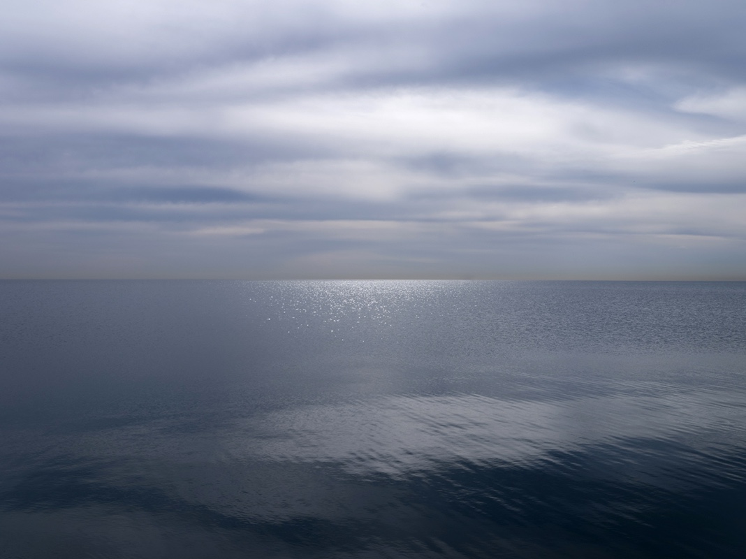 Alternating between light and dark, there is a surreal and almost stone-like quality to the clouds overhead Lake Michigan in this photograph from the Lake Series, May 16th, 2023.