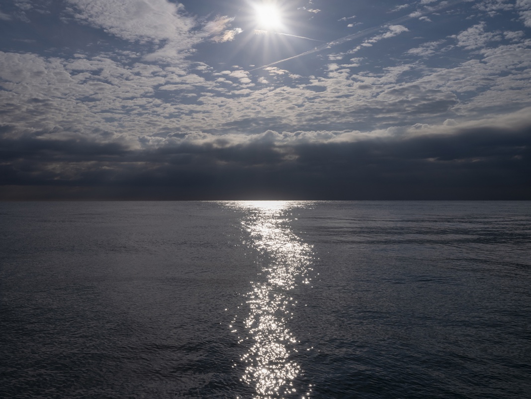 A trail of light shifts and shimmers across the surface of Lake Michigan in this photograph from the Lake Series, March 21st, 2024.