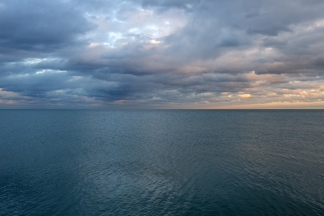 A detail from an early photograph in the Lake Series where the light is delicately illuminating the edges of rippling clouds, warming them from above, and creating waves of cool and warm color tones in the sky.