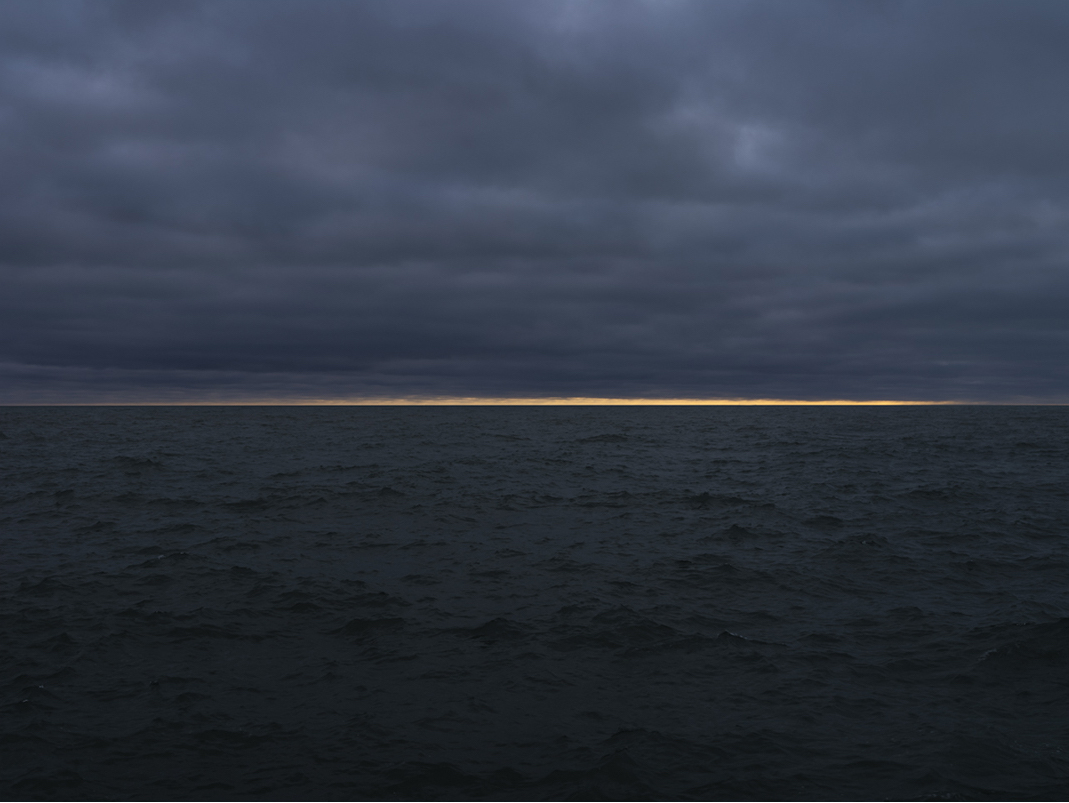 A slash of golden light cuts across the sky just above the water of Lake Michigan, the rest of the landscape is just beginning to come in to light on this early February day from 2024. 