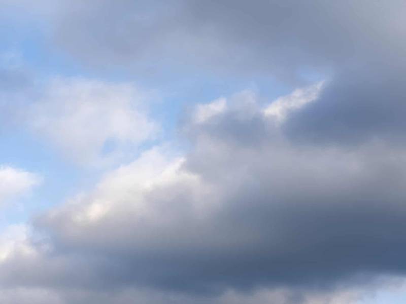 big clouds are filling a light blue sky